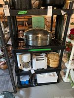 Full view of the black heavy duty plastic shelf unit loaded with various household items for context.