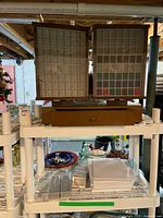 Wooden jewellery display case on white metal shelving with grid compartments visible behind glass