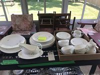 Full set displayed showing stacks of dinner plates, teacups, saucers, and a gravy boat with underplate on a table.