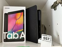 Samsung Galaxy Tab A box and tablet in black case inside cabinet
