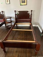 Full view of assembled bed frame showing headboard, footboard, side rails and slats