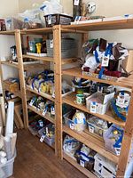 Two rows of wooden IKEA shelves with multiple items stored on them, shelves are natural wood color and rectangular shape.