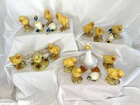 Full assortment of ceramic bird figurines displayed on white fabric background, including chicks, ducks, and a white goose.