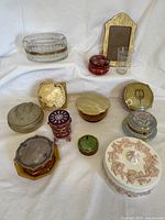 Overview of clear glass oval jar, celluloid picture frame, etched tumbler, red glass jar and assorted celluloid jars