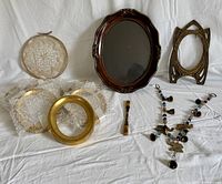 Mixed lot showing all items including large wood frame, brass frame, six small gold-leaf frames, lace doily in wicker hoop, Kogai hairpin, and beaded garland