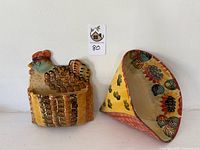 Pair of ceramic Italian wall pockets; fan-shaped on the right with yellow and grapevine decor, rooster-shaped on the left with a basket