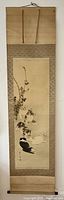 Full view of the Japanese hanging scroll showing the full length and mounted silk borders with wooden dowels at top and bottom.
