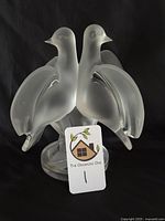 Front view of both doves and circular base on black background