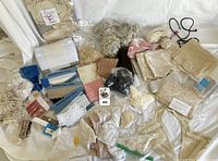 Overview of assorted lace trims, doilies, appliqué and handkerchiefs laid out on white backdrop