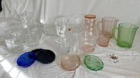 Wide view of assorted vintage glassware including tumblers, bowls, pitchers, coasters in various colors and styles