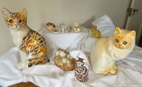 Group shot of nine cat figurines on white backdrop
