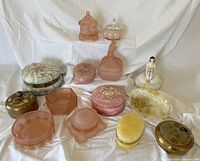 Overall group of 14 jars and dishes arranged on white drape