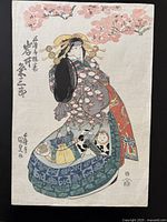 Front view of Kunisada print showing full-color image of courtesan under cherry blossoms on black backing