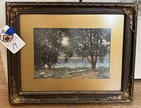Frontal image showing the framed watercolor painting of wooded riverbank scene with gold mat and decorative frame.