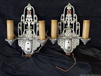 Pair of antique Art Deco double arm wall sconces with cast metal backplates and original polychrome paint.