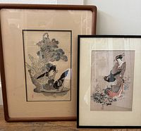 The full lot of two framed Japanese woodblock prints displayed side by side showing size and framing style.