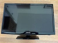 Front view of the Samsung 24 inch LED TV showing the screen and stand.