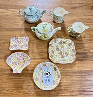 Top view of all items showing two stacking tea sets, one Blue Brocade Chintz, one Autumn Shade, plus four Clyde pattern dishes including shell and rectangular and two small plates.