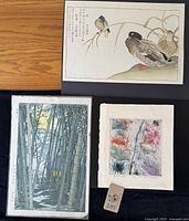 Overview of three unframed Japanese prints arranged on table