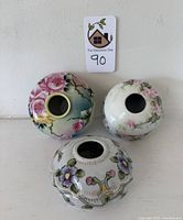 Top view of the three hair collection bowls showing floral designs and open centers.