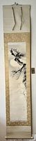 Full view of the hanging scroll depicting the plum blossom branch and full moon in sumi-e ink style on paper mounted on gold-toned silk brocade.