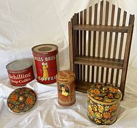 Photo showing full lot including wooden spice rack, two coffee tins, talcum powder tin, floral tin with lid, and an extra floral tin lid arranged on white backdrop.