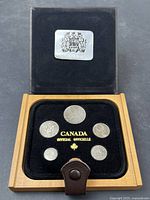 Photo showing the full official black velvet lined wooden case with transparent lid containing six coins from 1982.