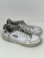 Front and side view of the Adidas men's running shoes showing wear, dirt, and branding on the side.