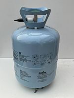 Front view of light blue AiRise helium balloon tank showing valve handle and printed instructions