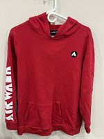 Front view of red Airwalk hooded sweater with hood, kangaroo pocket, and white branding on sleeve.