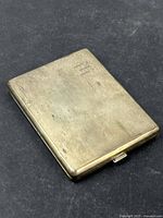 View of the closed sterling silver cigarette case showing its rectangular shape and slight surface wear.