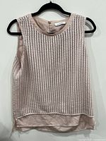 Front view of sleeveless Calvin Klein eyelet top in beige, showing texture and fabric detail.