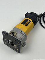 Yellow and black DeWalt DW670 trim router with metal base plate and attached power cord. Shows light signs of wear and use.