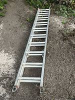 Full length view of the Featherlite aluminum extendable ladder resting on the ground showing the closed ladder at approximately 10 feet long.