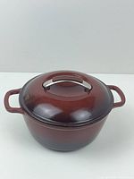 Front view of whole Dutch oven with lid on, showing deep red enamel and smooth surface.