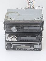 Stacked side view of 3 car stereo systems showing 2 Pioneer and 1 Subaru with metal chassis, some wear visible