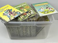 Plastic bin filled with numerous Little Golden Books, some stacked inside and three titles displayed on top: Animals' ABC, Doctor Dan the Bandage Man, Hansel and Gretel