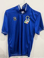 Front view of blue Italy soccer jersey size XL with Italy badge and small Roberto Baggio logo patch on chest.