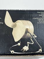 Close-up image of the fan blade and metal body showing cream color and vintage design with power cord attached