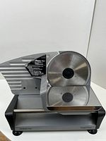 Full front side view of the Waring Pro food slicer showing the blade, stainless steel surface, and base.