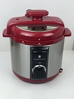 Front view showing the stainless steel and red pressure cooker with control panel and timer dial.