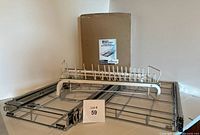 Four sliding metal organizers displayed together, one still sealed in original SimpleHouseware box along with a white sliding rack organizer and two flat wire grid sliding shelves with side rails.