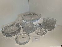 Photo of starburst pedestal bowl with 7 matching dessert bowls showing starburst and scalloped edges pattern.