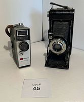 Photo showing both the Argus Automatic 8 movie camera and Kodak folding bellows camera side by side with Lot #45 card.