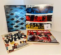 Photo showing The Who 'Tommy' double LP, The Police 'Synchronicity' LP, and two The Who collector publications arranged on table.