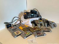 Nintendo 64 console with power adapter, AV cables, mini HDMI upscaler, three controllers, and ten game cartridges