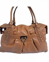 Front view of tan leather handbag with braided handle detailing and a metal clasp feature.