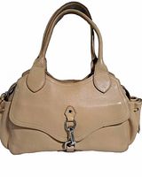 Front view of beige leather Cole Haan handbag with flap and clasp closure, showing handles and general style.