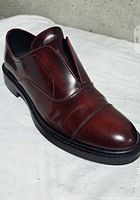 Single brick red leather loafer shoe angled to show side and top details