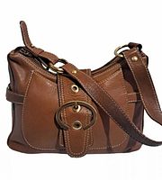 Front view of brown Luce leather handbag showing decorative buckle strap, adjustable shoulder strap, and overall shape.